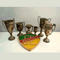 <p>Escudo esculpido em madeira e exemplares de troféus do Clube Esportivo, fundado em 1º de setembro de 1934.</p>