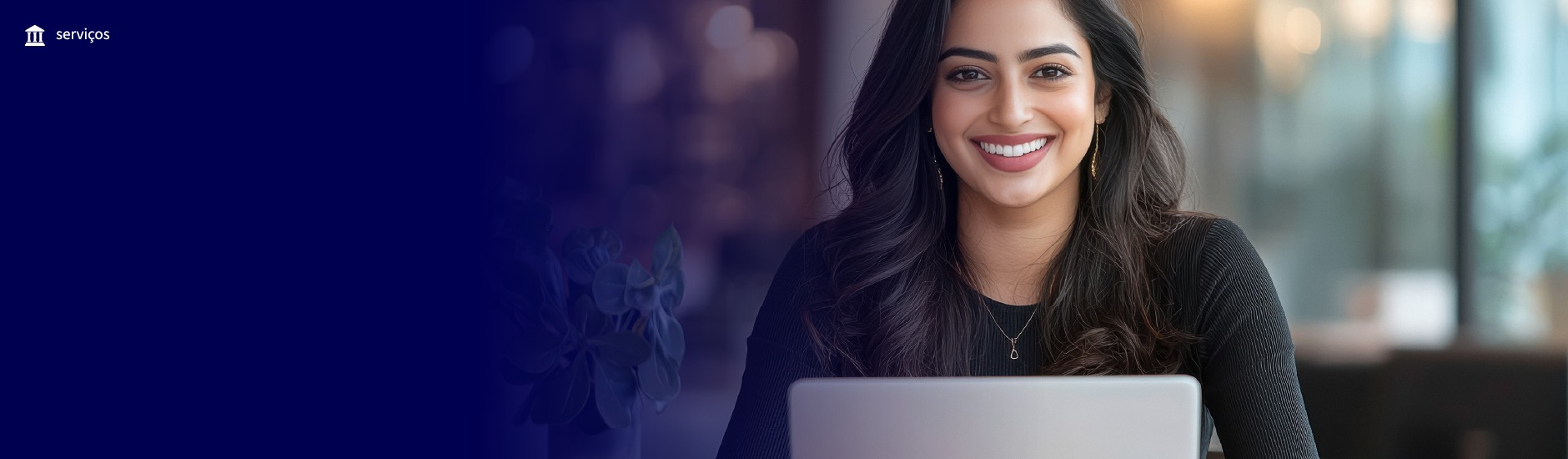 mulher de cabelos escuros sorrindo sentada com um notebook em frente