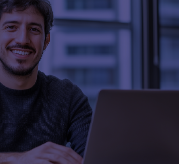 jovem sentado em mesa com notebook